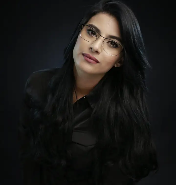 Portrait professionnel d'une femme à lunettes sur fond sombre