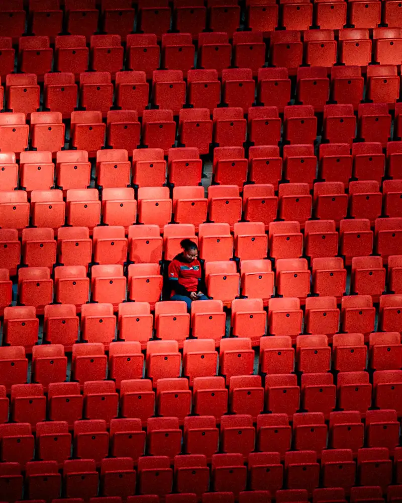 Supporter isolé dans les tribunes rouges d'un stade pendant la CAN 2025