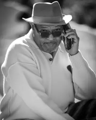 Portrait en noir et blanc d'un invité au chapeau, téléphone à l'oreille, FIFM 2025