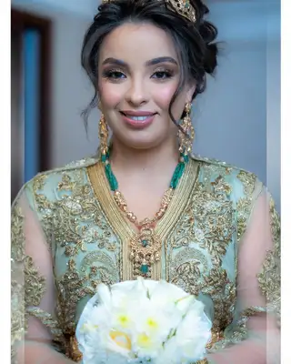 Mariée en caftan vert d'eau brodé d'or, diadème et bouquet de roses blanches