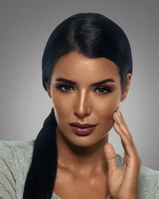 Visuel maquillage, peau hâlée, la main sur la joue, fond gris
