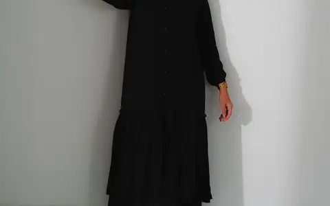 Modèle en robe noire et bottines, plan pied en studio
