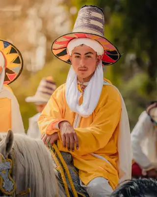 Cavalier au grand chapeau tressé et à la tenue jaune, en selle
