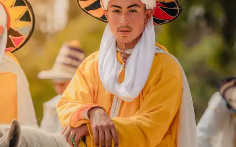 Cavalier au grand chapeau tressé et à la tenue jaune, en selle