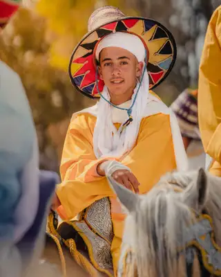 Jeune cavalier souriant en tenue jaune et chapeau traditionnel